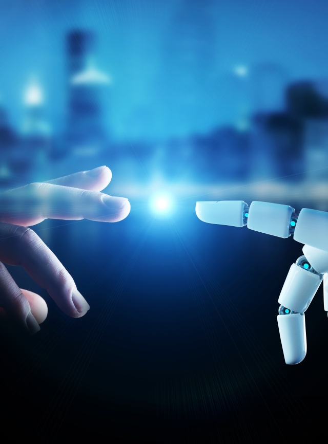 Funken zwischen Menschenhand und Roboterhand 
